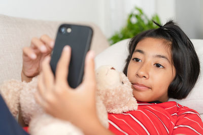 Portrait of boy using mobile phone at home