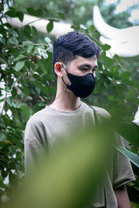 Side view of man wearing hat against plants