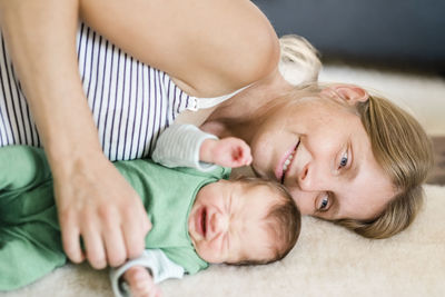 Cute baby lying on bed with mother at home