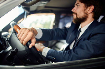 Side view of businessmen shaking hands while sitting in car