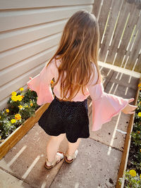 Side view of little girl standing on footpath