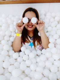 Cheerful young woman sitting amidst table tennis ball