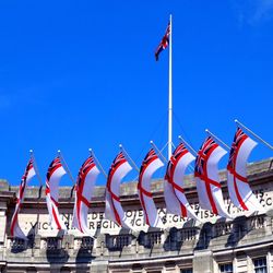 Low angle view of british flags on admiralty arch against sky