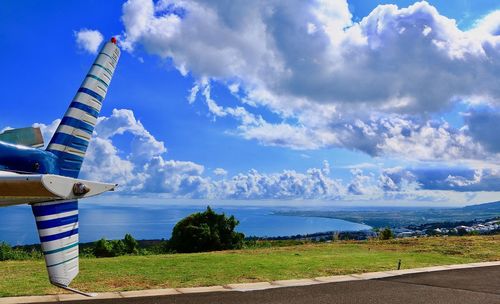 Airplane flying over landscape against blue sky