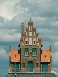 Low angle view of old building against cloudy sky