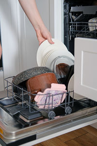 Man taking clean dishes out of dishwasher