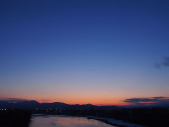 Scenic view of river against clear sky at sunset