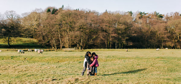 Rear view of people walking on field