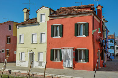 View of colorful houses on sunny day in burano, a gracious little town full of canals in italy.