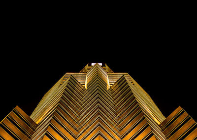 Low angle view of illuminated building against sky at night
