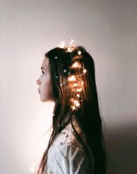 Portrait of young woman looking away against wall