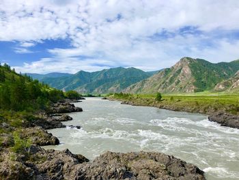 Scenic view of river amidst mountains against sky