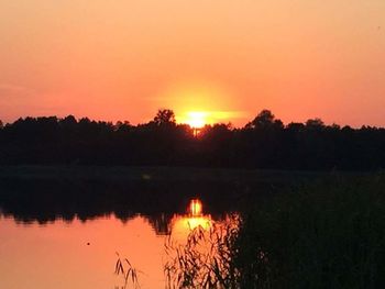 Scenic view of lake against orange sky