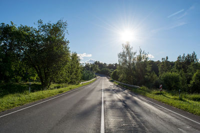 Road amidst trees against sky