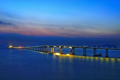 Bridge over calm sea against sky