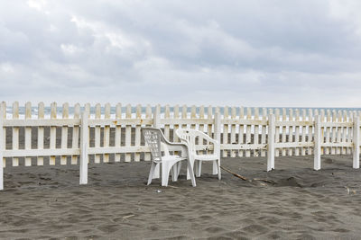 View of chairs on beach against sky