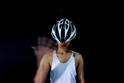 Portrait of a woman wearing mask against black background