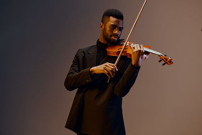 Midsection of man playing violin