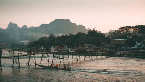 Scenic view of river by buildings against clear sky