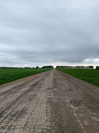 Road amidst field against sky