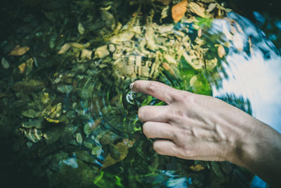 Close-up of hand against water