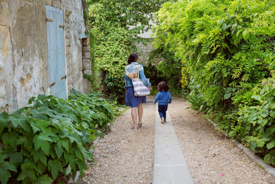 Mother and handsome baby boy walking outdoor in old city park