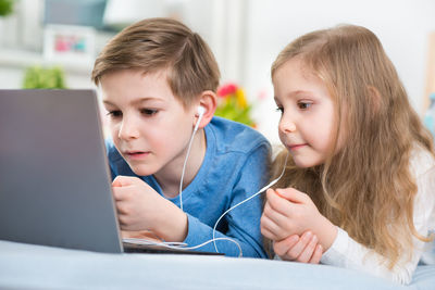 Boy with sister using laptop at home