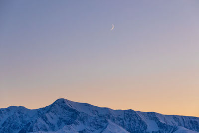 Scenic view of snowcapped mountains against sky during sunset