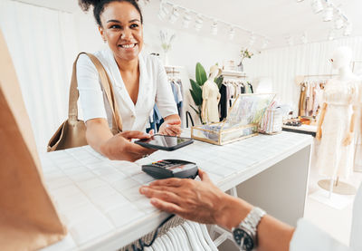 Midsection of woman using calculator while sitting on table