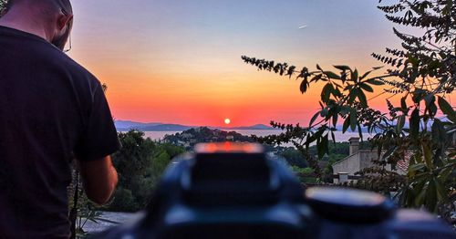 Man photographing orange sky during sunset