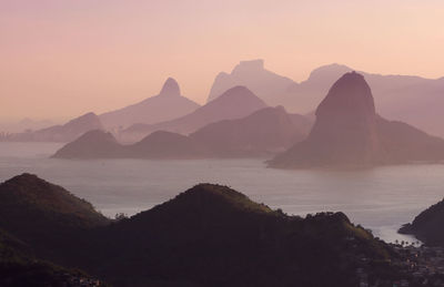 Scenic view of sea and mountains against clear sky