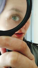 Close-up portrait of young woman holding eyeglasses