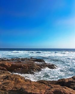 Scenic view of sea against clear blue sky