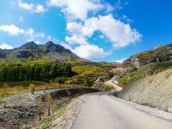 Road leading towards mountains against sky