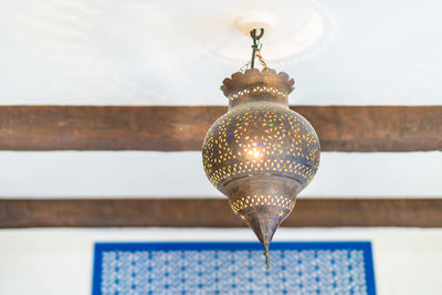 Low angle view of illuminated pendant light on wall