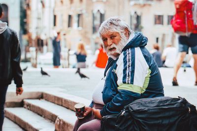 People sitting on street in city