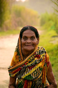Portrait of smiling senior woman wearing sari standing outdoors