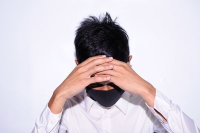 Portrait of man holding hands against white background