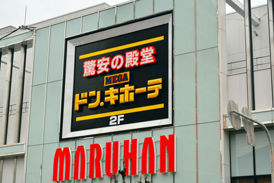 Low angle view of information sign against building