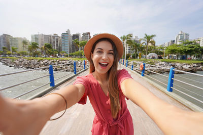 Happy laughing fashion woman takes self portrait in the city of florianopolis santa catarina, brazil