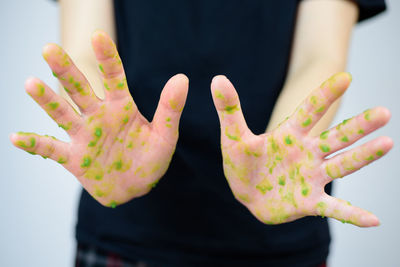 Close-up of hand over colored background