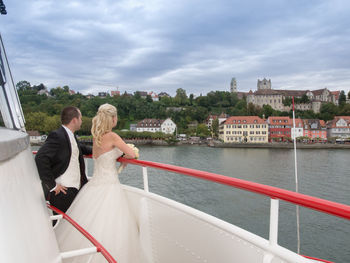 Newlywed couple standing in boat at sea