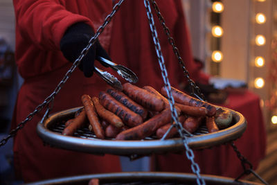 Midsection of person weighing sausages