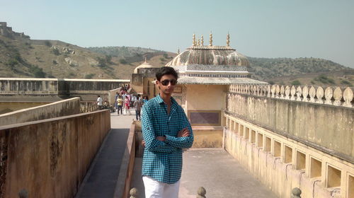 Portrait of a young man standing on railing