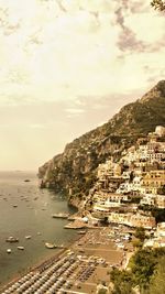 Aerial view of townscape by sea against sky