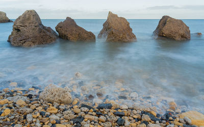 Rocks in sea against sky