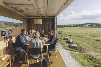 Business people discussing at desk in portable office truck by field