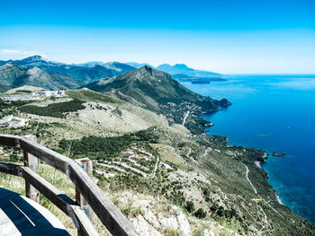 High angle view of sea and mountains against blue sky