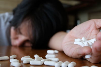 Close-up of woman with pills on table