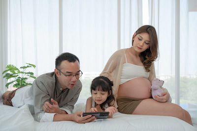 Female friends sitting on bed at home